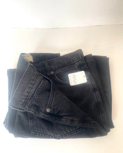Load image into Gallery viewer, A pair of folded black denim jeans with a white paper tag attached, displayed on a plain white surface.