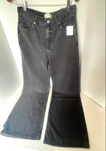 Load image into Gallery viewer, A pair of dark gray washed flare jeans hanging on a metal hanger against a white background.