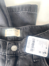 Load image into Gallery viewer, Close-up of a pair of dark gray washed denim jeans showing the waistband, a beige 'The The Free' brand label, a silver metal button, and a white H&amp;M product tag.