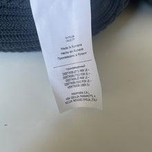 Load image into Gallery viewer, Text label on a product with multiple languages and text, on a blurred background.