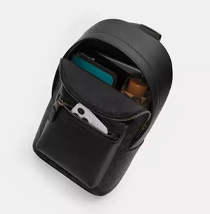 Black crossbody bag with compartments on a light gray background