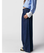 Load image into Gallery viewer, Person wearing blue wide-leg jeans and a light blue denim shirt on a white background