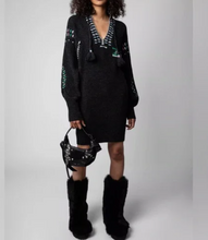 Load image into Gallery viewer, Woman wearing a black dress with decorative elements and black fur boots on a white background