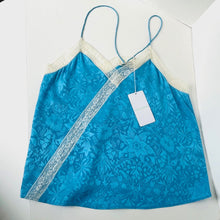 Load image into Gallery viewer, Blue floral-patterned top with a white tag on a white background