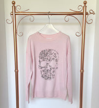 Load image into Gallery viewer, Pink sweater with skull design on a hanger against a white background