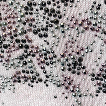 Load image into Gallery viewer, Close-up of a fabric with black and silver rhinestones on a light pink background