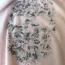 Load image into Gallery viewer, Close-up of a fabric with intricate beadwork on a light pink background