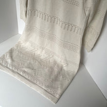 Load image into Gallery viewer, Beige knitted blanket with intricate patterns draped over a white surface