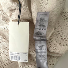 Load image into Gallery viewer, Close-up of a beige knitted sweater with tags on a light background