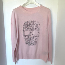 Load image into Gallery viewer, Pink sweater with skull design on a hanger against a white background