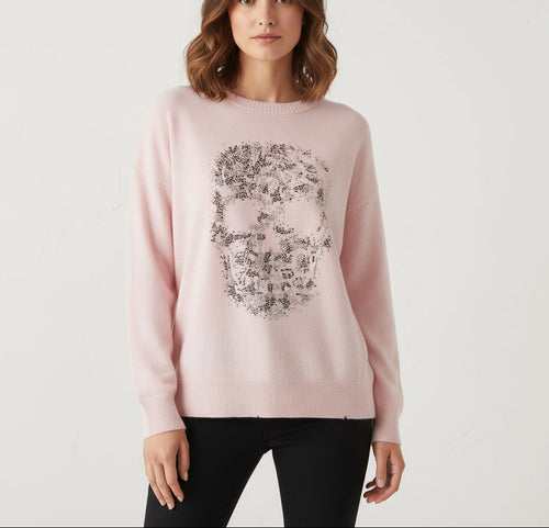 Pink sweater with skull design on a hanger against a white background