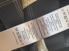 Load image into Gallery viewer, Close-up of a fabric label with text and symbols on a black garment.