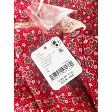 Load image into Gallery viewer, Red floral fabric with a clothing tag on a white background