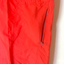 Load image into Gallery viewer, Red pants with a blue zipper on a beige background