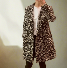 Load image into Gallery viewer, Person wearing a leopard print coat in a room with wooden flooring and a door.