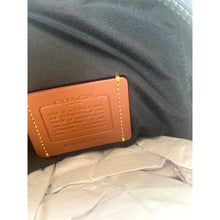 Load image into Gallery viewer, Coach brand tag on a denim fabric background
