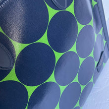 Load image into Gallery viewer, Close-up of a bag with blue circular patterns on a green background