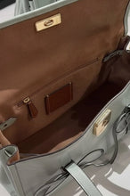 Load image into Gallery viewer, Close-up of a light gray handbag with brown interior and gold hardware on a white background.