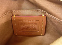 Load image into Gallery viewer, Close-up of a Coach bag label on a brown leather bag.