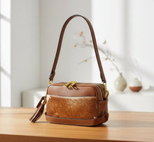 Load image into Gallery viewer, Brown leather handbag with cowhide pattern on a light gray background