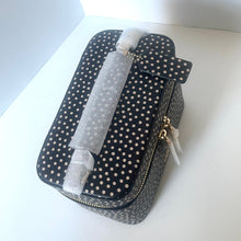 Load image into Gallery viewer, Polka dot travel case with a bottle inside on a white surface
