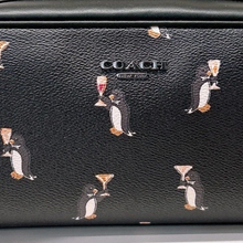 Load image into Gallery viewer, Coach black leather bag with penguin print on a light gray background