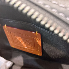 Load image into Gallery viewer, Close-up of a textured surface with a brown label and zipper