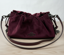 Load image into Gallery viewer, Maroon handbag with black straps on a wooden surface