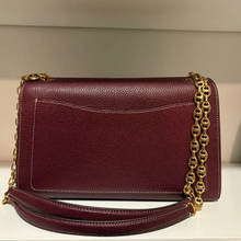 Load image into Gallery viewer, Maroon handbag with gold chain strap on a neutral background