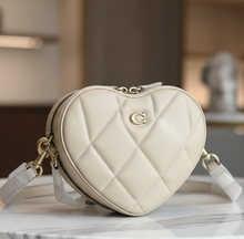 Load image into Gallery viewer, Beige quilted handbag with gold zipper on a magazine background