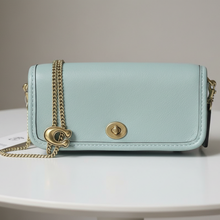 Load image into Gallery viewer, Light blue handbag with gold chain and clasp on a dark background
