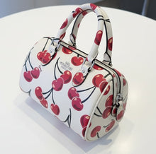 Load image into Gallery viewer, Handbag with cherry pattern held by a hand on a wooden floor.