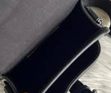 Load image into Gallery viewer, Close-up of a black suitcase with a patterned fabric surface