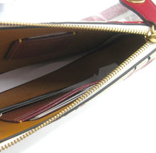 Load image into Gallery viewer, Close-up of an open red leather wallet or clutch with gold-tone zipper, tan interior lining, card slots, and a hand holding it open.
