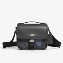 Load image into Gallery viewer, Coach black handbag with logo on a wooden surface