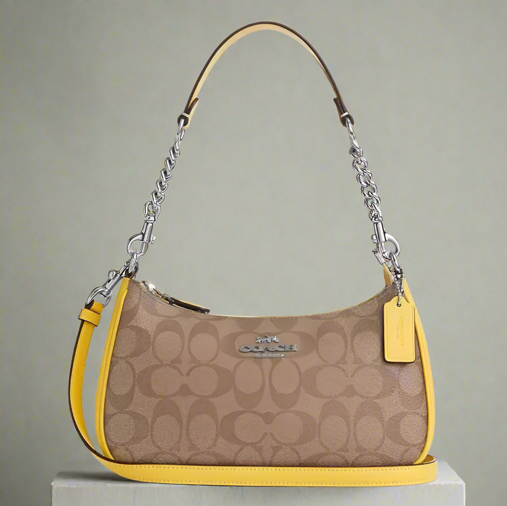 Coach handbag with brown pattern and yellow accents on a white background