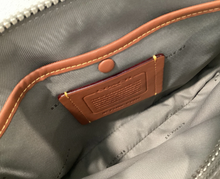 Load image into Gallery viewer, Close-up of a gray bag with brown stitching and a brand label.