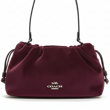 Load image into Gallery viewer, Maroon handbag with Coach logo on a beige background