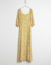 Load image into Gallery viewer, Yellow floral dress on a mannequin against a tiled wall background
