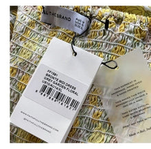 Load image into Gallery viewer, Clothing tag with product details on a floral dress