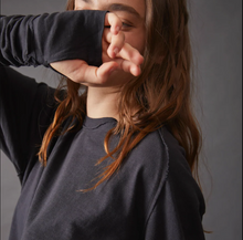 Load image into Gallery viewer, Person wearing a dark long-sleeve shirt with another arm covering their face against a neutral background