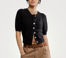 Load image into Gallery viewer, Person wearing a black cardigan with white buttons on a plain background