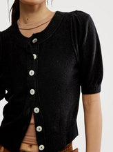 Load image into Gallery viewer, Black cardigan with white buttons worn by a person on a plain background