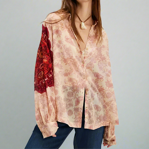 Floral blouse with a red sleeve detail worn by a person on a white background