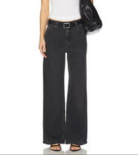 Load image into Gallery viewer, A model wearing a pair of wide-leg black denim jeans with a matching black belt, styled with a white tank top, black sandals, and a black shoulder bag against a white background.