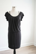 Load image into Gallery viewer, A dark gray short-sleeve camisole dress with thin shoulder straps, displayed on a white mannequin torso in an indoor setting.