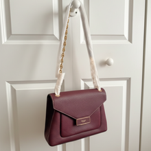 Load image into Gallery viewer, Maroon handbag with gold chain strap on a white background