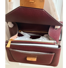 Load image into Gallery viewer, Open maroon handbag with gold accents on a white background