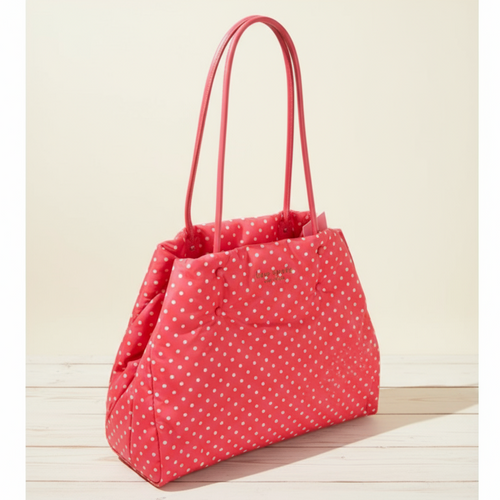 Red polka dot handbag with pink handles on a wooden surface