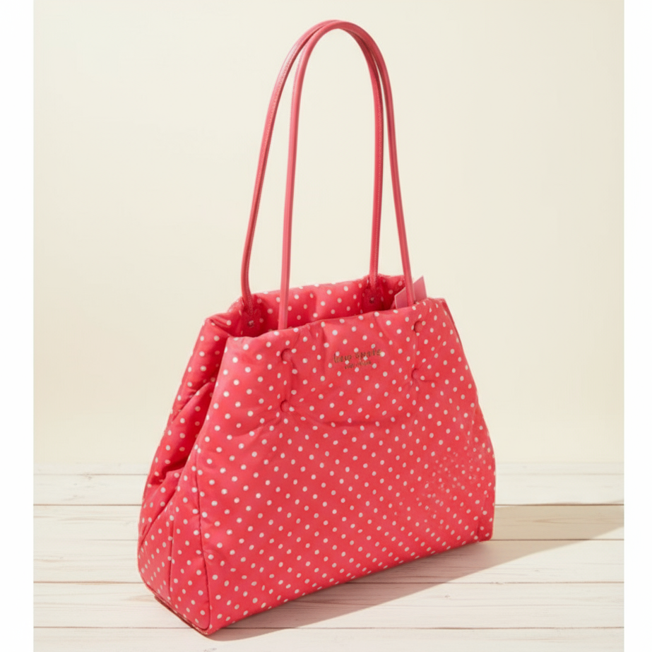Red polka dot handbag with pink handles on a wooden surface